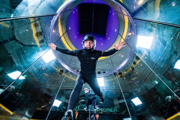 Person Flying And Looking At Camera In Wind Tunnel