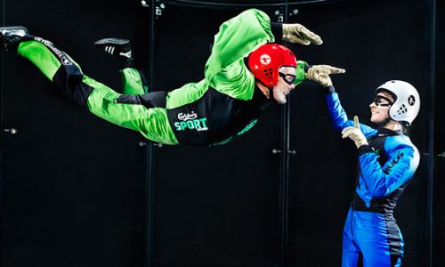 Instructor working with a first time flyer in a wind tunnel