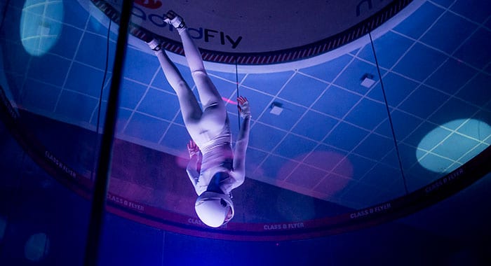 Girl in a white suit diving in the flight chamber